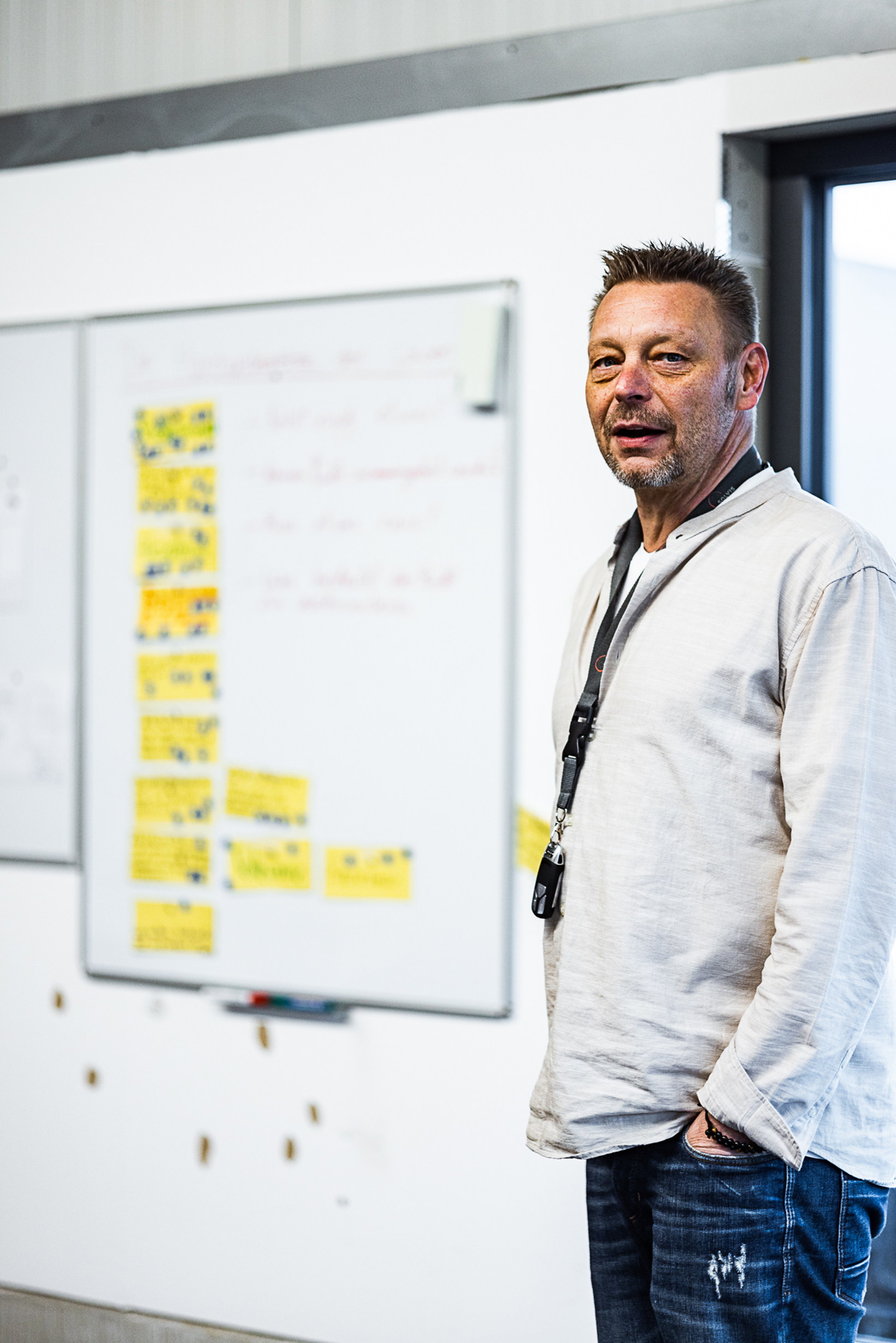 Mann präsentiert Kanban-Board mit gelben Notizzetteln in modernem Büro der Roten Löwen GmbH zur Kultur- und Markenentwicklung